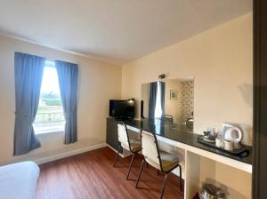 a room with a desk with chairs and a window at The Weigh Inn Hotel & Lodges in Thurso