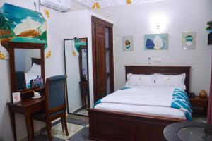 a bedroom with a bed and a table and a chair at lynna hôtel in Yaoundé