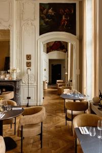 a restaurant with tables and chairs and a fireplace at Hôtel Royal Beaulaincourt in Béthune