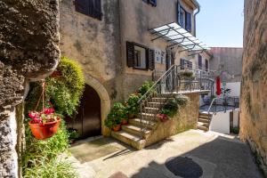 an alley with stairs and flowers in a building at Casa Nadia by Briskva in Mošćenička Draga