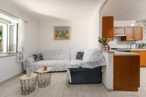 a living room with a couch and a kitchen at Casa Nadia by Briskva in Mošćenička Draga
