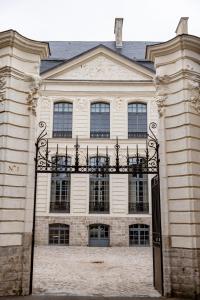 a large building with a gate in front of it at Hôtel Royal Beaulaincourt in Béthune