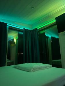 a bedroom with a bed with blue lights on it at Casuta Artar - Therme & Aeroport Otopeni in Corbeanca