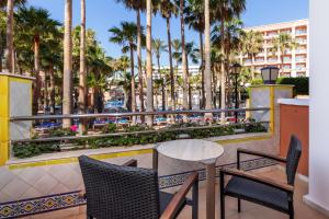 a balcony with a table and chairs and palm trees at Playacapricho in Roquetas de Mar