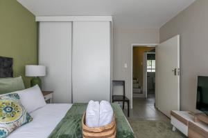 a bedroom with a bed and a living room at Mistica on St James in Johannesburg