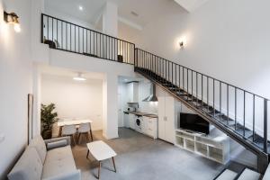a living room with a couch and a staircase at Apartamentos Cayetana in Badajoz