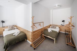 two twin beds in a room with white walls at Apartamentos Cayetana in Badajoz