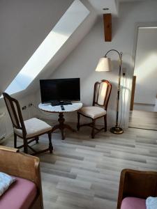 a living room with a tv and a table and chairs at Haus Carl-Hubert -Schwerin Görries - in Klein Rogahn