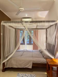 a bedroom with a canopy bed with a window at THC - Tropical Hideaway Ceylon in Talpe