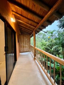 a balcony of a house with a wooden ceiling at Suíte em Trindade, Praia Brava, na Mata in Paraty