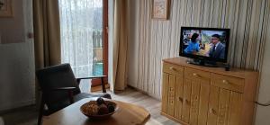 a living room with a television on a dresser at Aparthotel Schafshorn in Schaprode