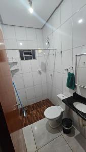 a bathroom with a shower and a toilet and a sink at Casa próxima à Praia do Cerrado e centro in Goianésia