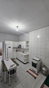 a kitchen with a refrigerator and a table in it at Casa próxima à Praia do Cerrado e centro in Goianésia