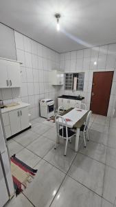 a kitchen with a table and chairs in it at Casa próxima à Praia do Cerrado e centro in Goianésia +6 photos