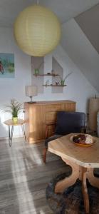 a living room with a wooden table and a large lamp at Aparthotel Schafshorn in Schaprode