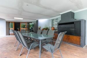 a dining room with a glass table and chairs at Mistica on St James in Johannesburg