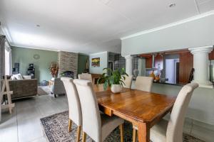a dining room with a wooden table and chairs at Mistica on St James in Johannesburg