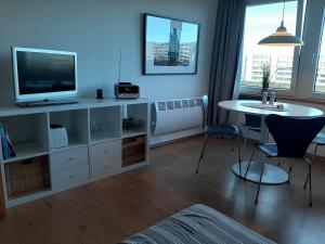 a living room with a television and a table with chairs at Möwenhorst in Fehmarn