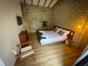 a bedroom with a bed and a chair in it at Quinta Casal de Bordeiro in Góis