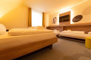 a hotel room with two beds and a television at BDB-Kulturhotel in Staufen im Breisgau +14 photos