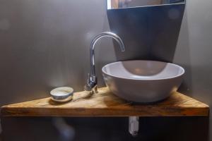 a bowl sink on a wooden counter with a faucet at Dimora Del Teatro in Vigevano