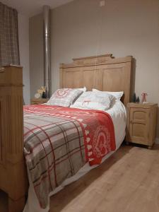 a bedroom with a large bed with a wooden headboard at L'Ultra Pause au cœur du Viroin in Olloy-sur-Viroin