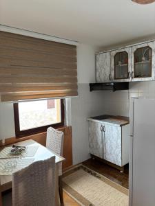 a small kitchen with a table and a refrigerator at Apartmani Rada in Zlatibor