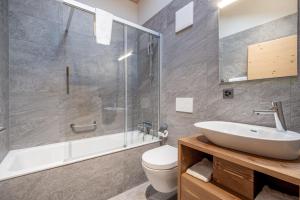 a bathroom with a sink and a toilet and a shower at SWISSPEAK Resorts by Pierre & Vacances Premium Vercorin in Vercorin