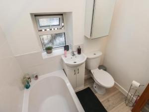 a bathroom with a tub and a toilet and a sink at Chestnut Lodge in Bradford +10 photos