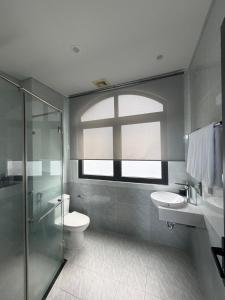 a bathroom with a toilet and two sinks and a window at Tom Tom Homestay in Phú Quốc