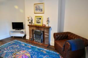 a living room with a couch and a fireplace at Ash Cottage - Caerleon in Newport