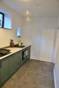 a kitchen with green cabinets and a counter top at Ash Cottage - Caerleon in Newport