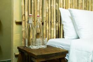 two wine bottles on a wooden table next to a bed at Ruby's Home- Doc Let's House in Ngân Hà