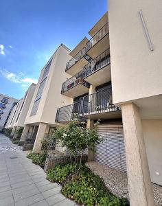 a large apartment building with balconies and a sidewalk at Bella Apartments Brno in Brno