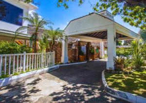 a house with a white fence and a driveway at Grand Hotel Excelsior Port Royal in Kingston