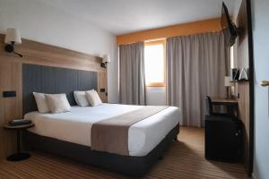 a hotel room with a large bed and a window at The Originals City, Hôtel Napoléon, La Roche-sur-Yon in La Roche-sur-Yon +21 photos