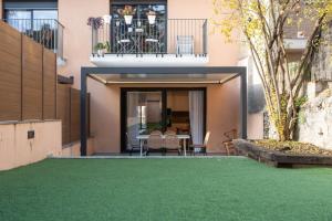 a house with a green lawn in front of it at Modern apartments in one building, in the heart of Girona in Girona