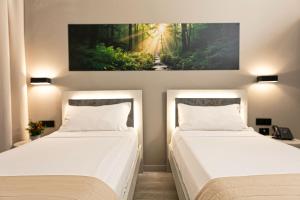 two beds in a bedroom with a painting on the wall at Break Hotel in Ospedaletto Lodigiano +45 photos