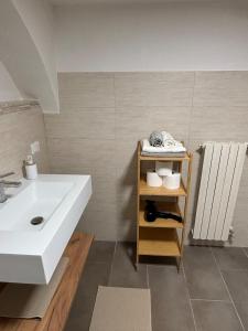 a bathroom with a white sink and a shelf with towels at Il vicoletto in Sulmona +19 photos