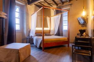 a bedroom with a four poster bed and a television at Dimora Del Teatro in Vigevano