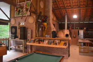 a room with a pool table and a brick wall at Rancho Potala in Bairro Pedra Branca