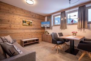 a living room with wooden walls and a table and chairs at Appart Christophorus in Söll