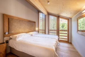 a bedroom with two beds and a large window at SWISSPEAK Resorts by Pierre & Vacances Premium Vercorin in Vercorin +94 photos