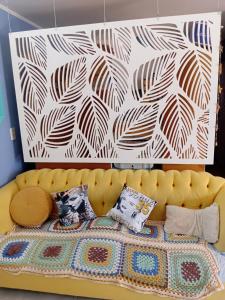 a yellow couch in a room with a wall at casa azul in Plottier +14 photos