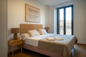 a bedroom with a bed with two towels on it at Modern apartments in one building, in the heart of Girona in Girona
