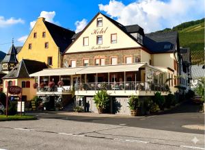 a large white building with a restaurant on a street at Hotel Moselterrasse in Ediger-Eller