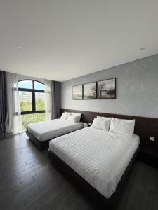 a hotel room with two beds and a window at Tom Tom Homestay in Phú Quốc