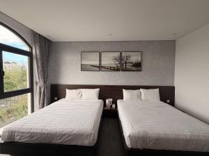 two beds sitting next to each other in a room at Tom Tom Homestay in Phú Quốc