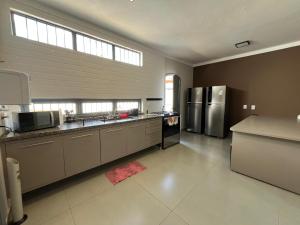 a large kitchen with stainless steel appliances at Astor Suítes - Unicamp in Campinas