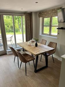 a dining room with a wooden table and chairs at LODGE Nuthatch in Droitwich +8 photos